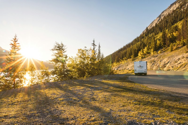 A motorhome on a winding mountain road at sunset